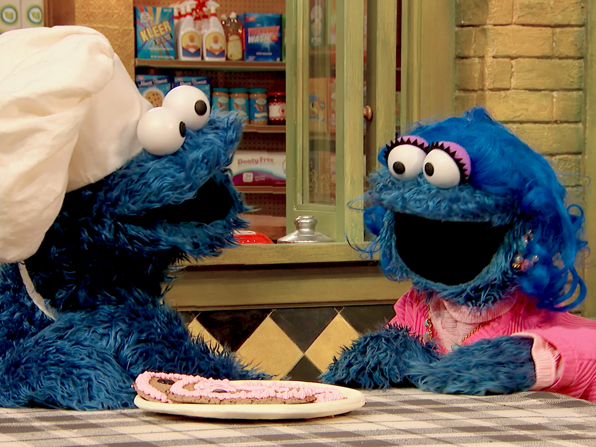 Cookie Monster with his mom, showing a heart-shaped cookie.