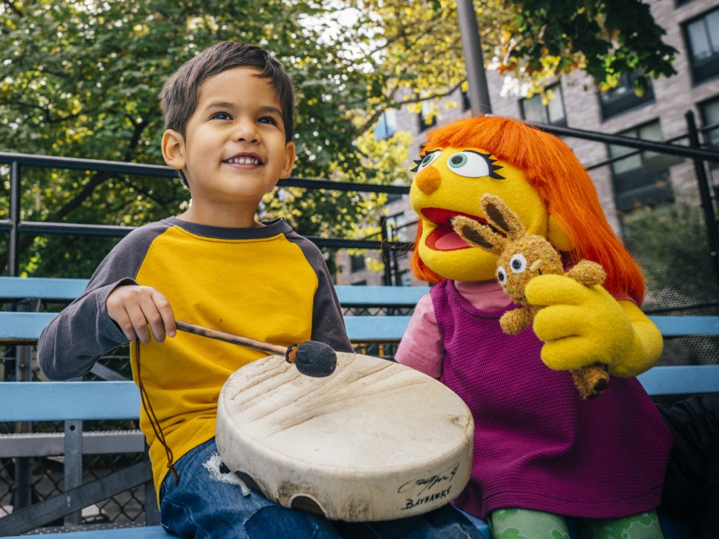 A child playing the drum with Julia.