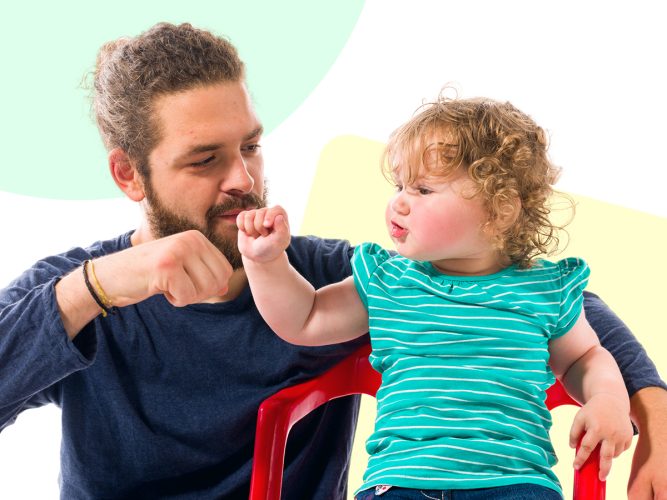 A parent gives their child a fist bump