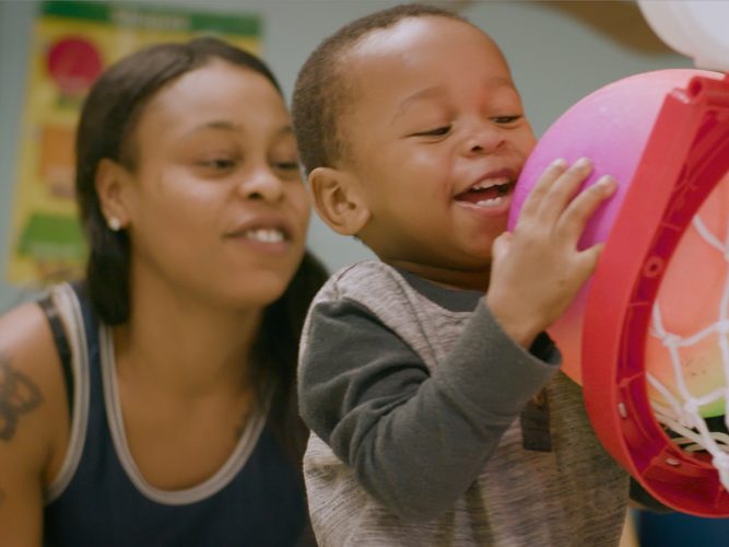 Parent and child playing basketball.