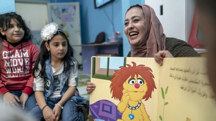 Woman reading to a classroom.