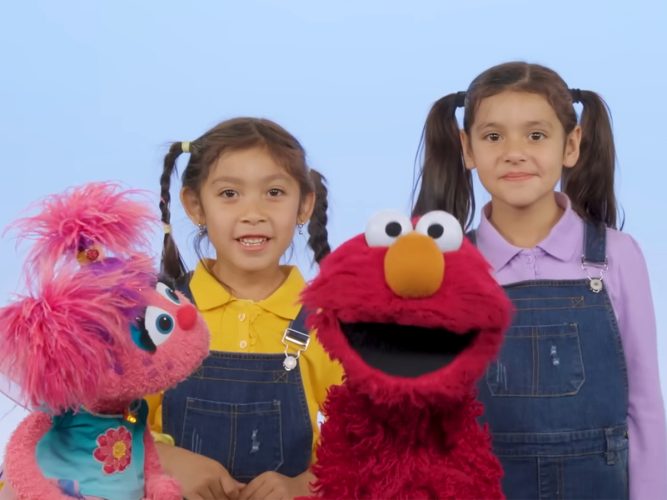 Two children with Elmo and Abby Cadabby.
