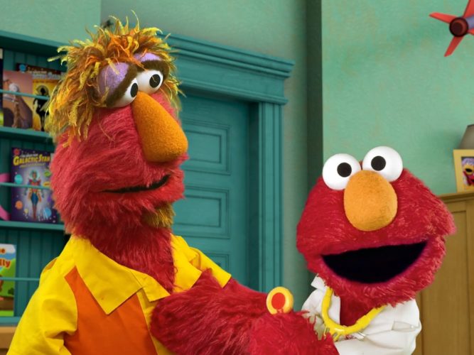 Elmo dressed as a doctor playing with his dad Louie.