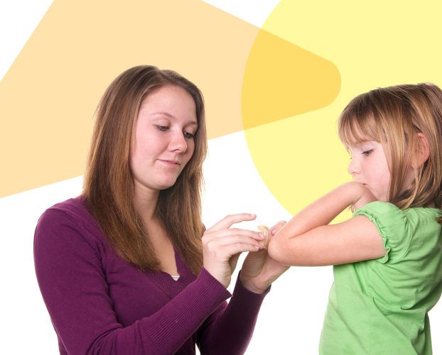 A parent puts a band-aid on their child